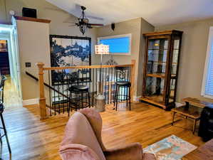 Living room with wood finished floors and a ceiling fan