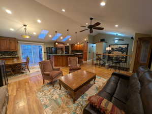 Living area featuring light wood-type flooring, a skylight, ceiling fan, and recessed lighting