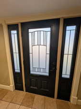 Foyer entrance with tile patterned flooring and baseboards