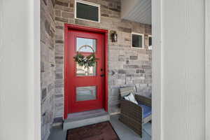 Entrance to property featuring stone siding