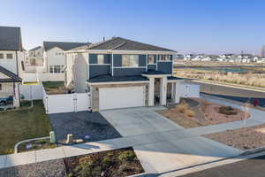 View of front of house with a gate, a residential view, roof with shingles, a garage, and concrete driveway