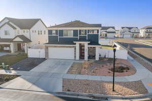 View of front of property featuring a gate, a residential view, driveway, and a garage