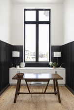 Office space with a wainscoted wall and light wood-style flooring