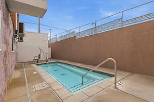 View of heated spa with patio surround and a pool