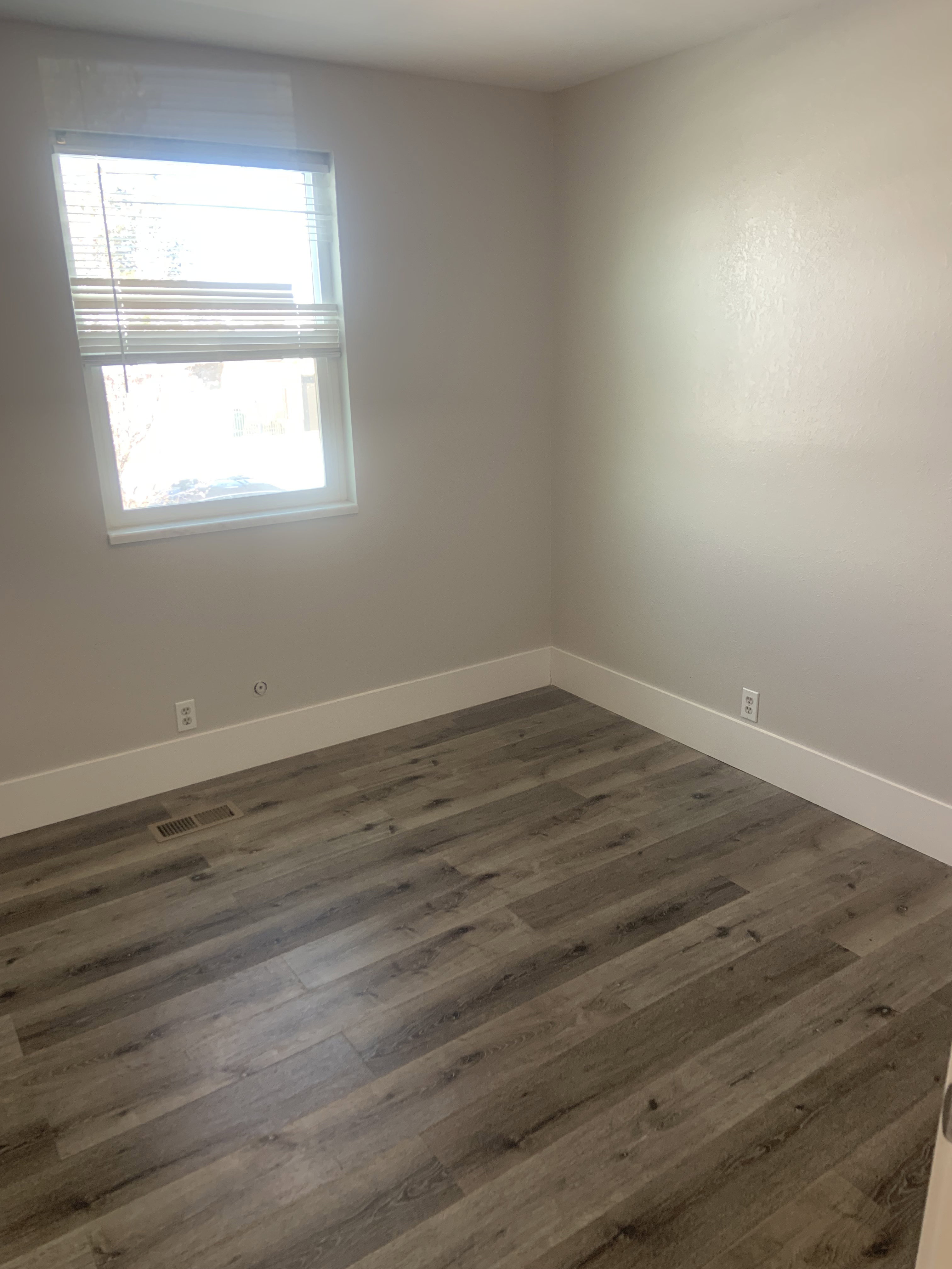 Neutral wall tones complement the wood-finish flooring in this room
