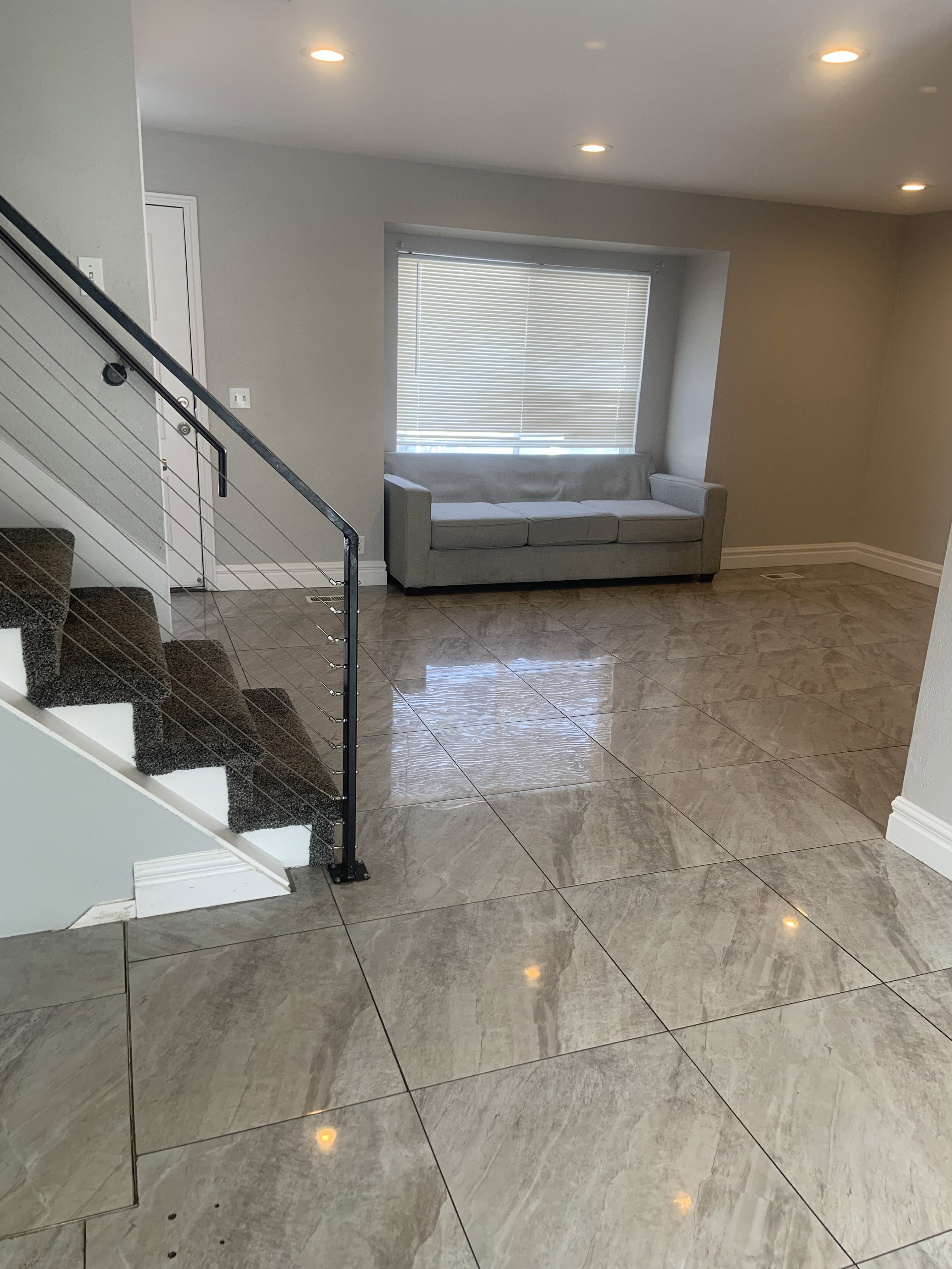 Spacious room featuring large format tile flooring and recessed lighting