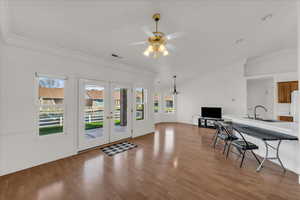 Office space with french doors, lofted ceiling, crown molding, light wood-style floors, and a ceiling fan