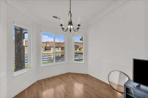 Unfurnished dining area featuring wood finished floors and suspended lighting