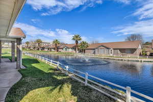 View of pool featuring a water view, a yard, a residential view, and patio surround