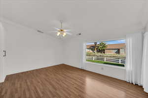 Unfurnished room with light wood-style floors, a ceiling fan, and crown molding