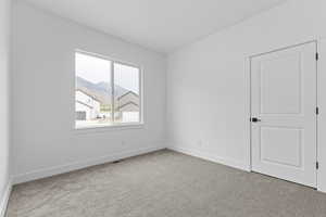 Spare room featuring light colored carpet and baseboards