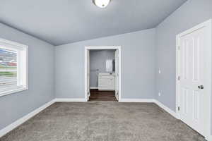 Unfurnished bedroom featuring ensuite bathroom and carpet flooring