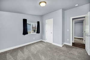Unfurnished bedroom with carpet floors, a closet, and a textured ceiling