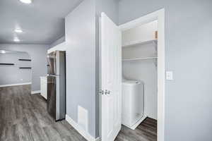 Laundry area featuring washer / clothes dryer, light wood-style flooring, a textured ceiling, and recessed lighting
