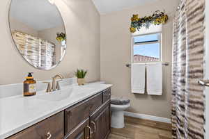 Bathroom featuring vanity, curtained shower, and light wood-style floors