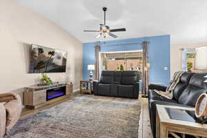 Living area featuring light wood-style floors, ceiling fan, and lofted ceiling