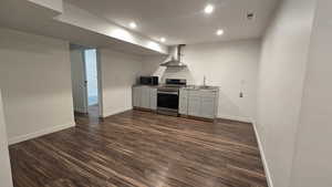 Kitchen with stainless steel appliances, dark wood finished floors, gray cabinets, recessed lighting, and light countertops
