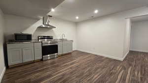 Kitchen featuring stainless steel appliances, gray cabinetry, dark wood-style floors, recessed lighting, and dark stone countertops