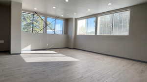 Empty room featuring light wood-style floors and recessed lighting