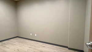Empty room with light wood-style floors and baseboards
