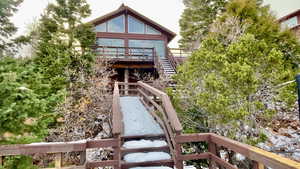 Back of property featuring a deck and stairs