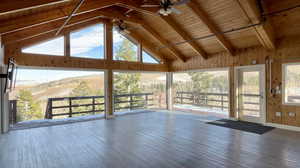 Unfurnished sunroom featuring beam ceiling