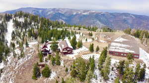 Aerial view of property and surrounding area featuring a mountainous background