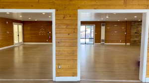 Empty room featuring recessed lighting, wood walls, wood finished floors, and a heating unit