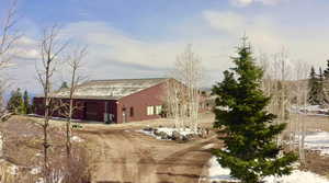 Snow covered property with driveway and a garage