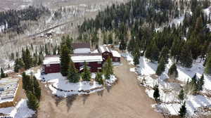 Snowy aerial view with a wooded view