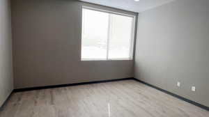 Spare room featuring light wood-style floors and baseboards