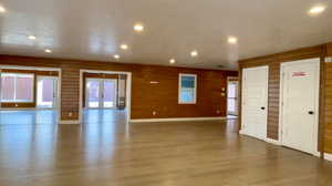 Spare room with french doors, log walls, recessed lighting, wood walls, and plenty of natural light