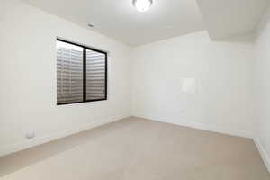 Carpeted spare room with baseboards