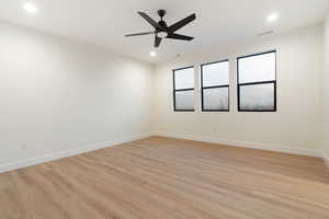 Empty room featuring light wood finished floors, ceiling fan, and recessed lighting