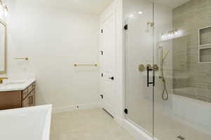 Bathroom with vanity, a stall shower, and a soaking tub