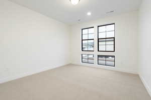 Empty room featuring light carpet and baseboards