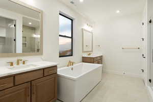 Bathroom featuring two vanities, a soaking tub, recessed lighting, light flooring, and a shower stall