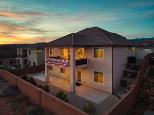 Rear view of property featuring a fenced backyard, a patio area, stucco siding, and a tile roof