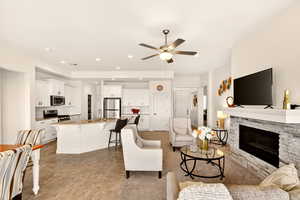 Living room featuring a fireplace, ceiling fan, and recessed lighting