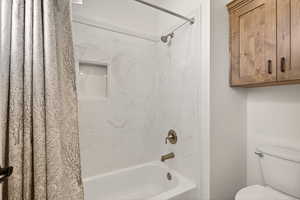 Full bathroom with shower / tub combo and toilet