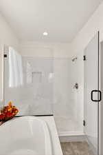 Full bathroom featuring a marble finish shower, recessed lighting, and a garden tub