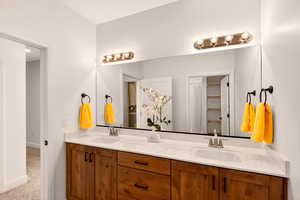 Bathroom with double vanity and carpet