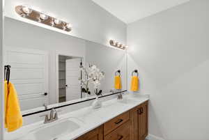 Full bath with double vanity and baseboards