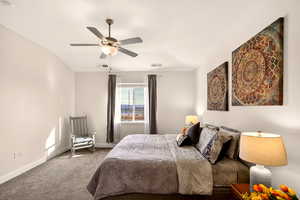 Carpeted bedroom featuring baseboards and ceiling fan
