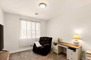 Office area featuring baseboards and dark colored carpet