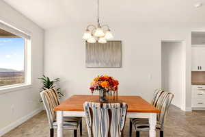 Dining space with a chandelier and vaulted ceiling
