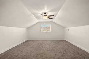 Additional living space featuring ceiling fan and carpet floors