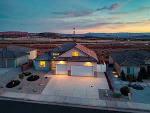 View of front of property featuring stone siding, an attached garage, stucco siding, concrete driveway, and a tile roof