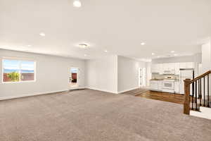 Unfurnished living room featuring dark colored carpet and recessed lighting