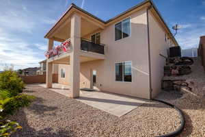 Back of property featuring a patio, a balcony, and stucco siding